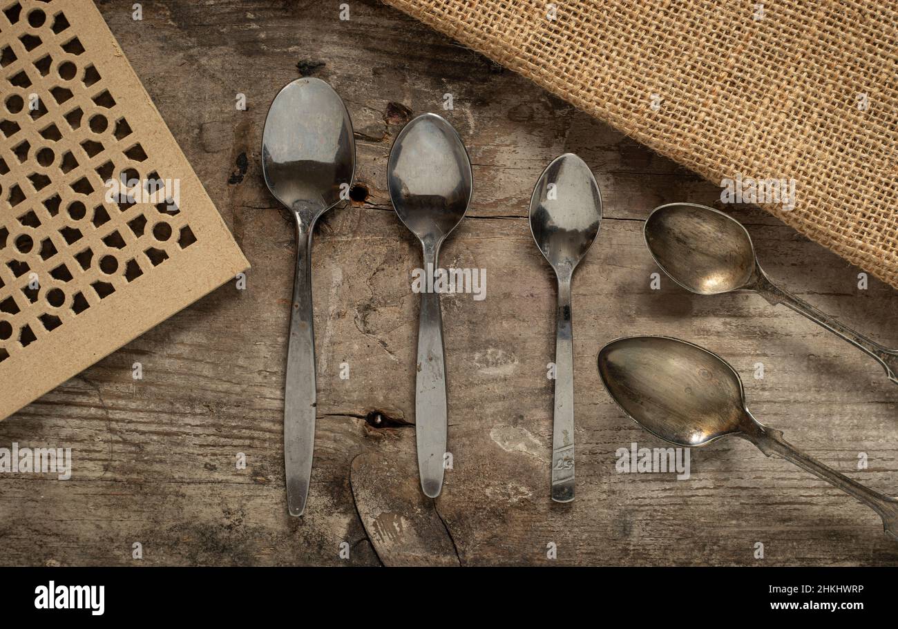close up macro collection of vintage silver spoons on a rustic background from above Stock Photo