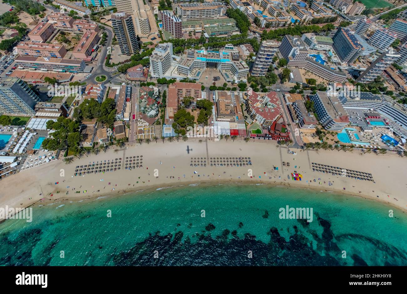 Aerial view, sandy beach Platja de Magaluf with hotel facilities, shadow of a plane, swimming pool on the roof Hotel INNSIDE by Meliá Calviá Beach The Stock Photo