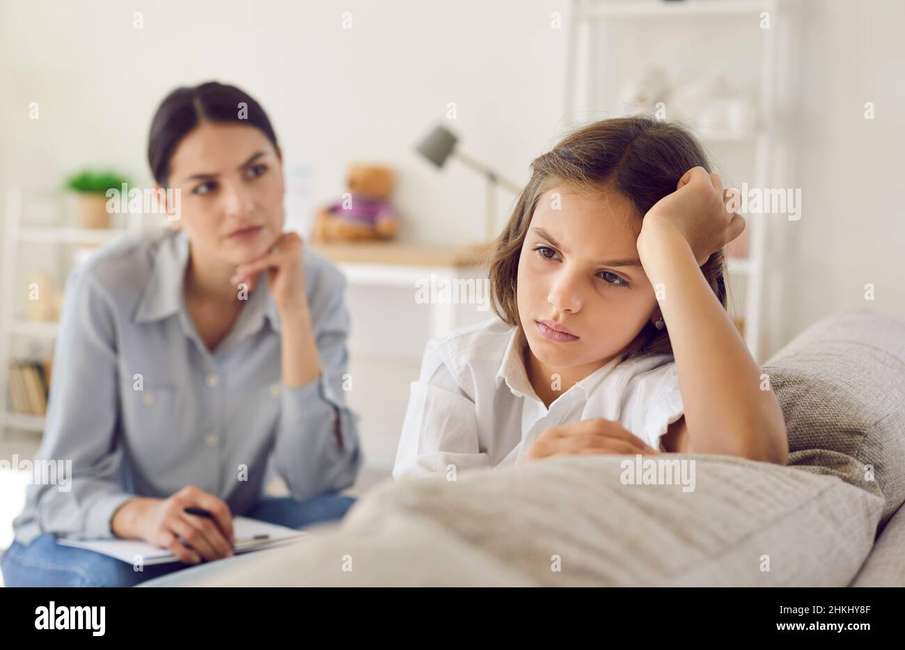 Sad child at therapist's or psychologist's office not ready to talk about problems and emotions Stock Photo