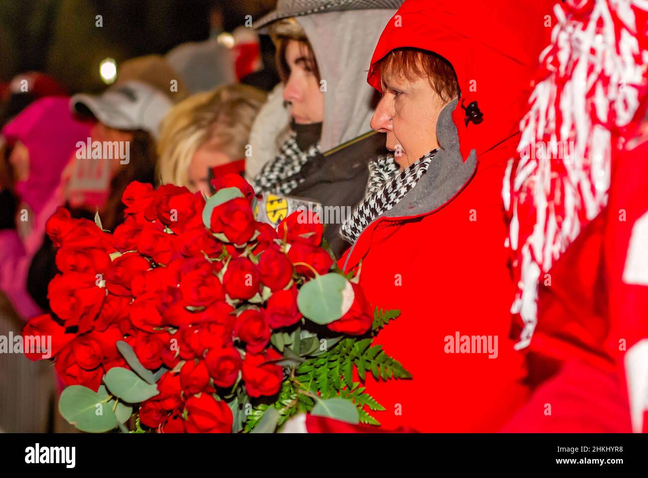 A Crimson Tide football fan holds a bouquet of roses as she waits to congratulate the team on the National Championship in Tuscaloosa, Alabama. Stock Photo
