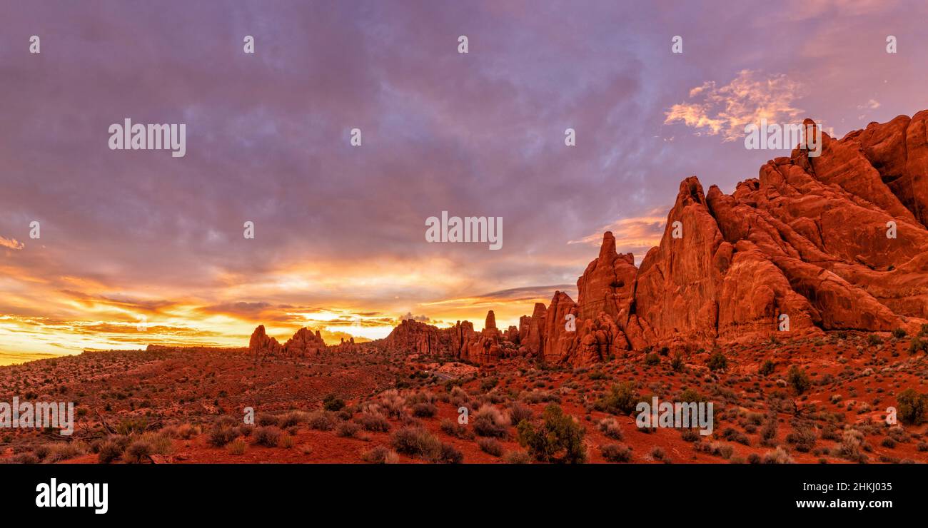 Fiery Furnace rock fins lit up red by  colorful sunset light due to the Pack Creek Fire, in Arches National Park, Moab, Utah. Stock Photo