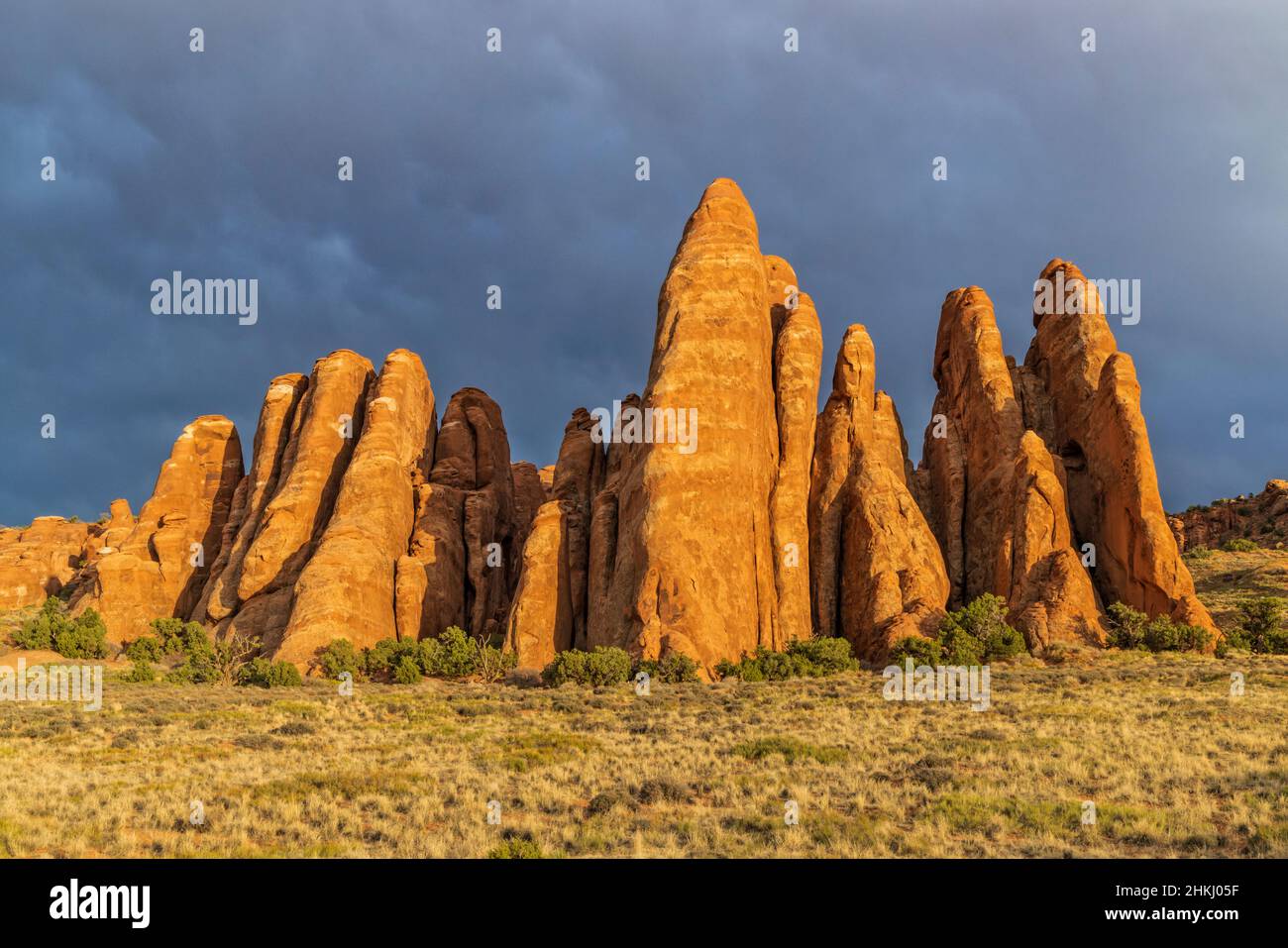 Sunlit red rock fins against a dark sky reminiscent of Stonehenge at Sand Dune Arch in Arches National Park near Moab, Utah. Stock Photo