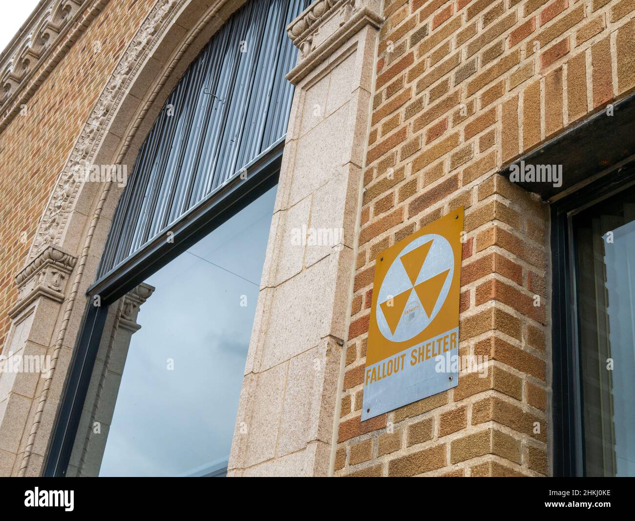 Old vintage fallout shelter sign on a brick exterior wall Stock Photo