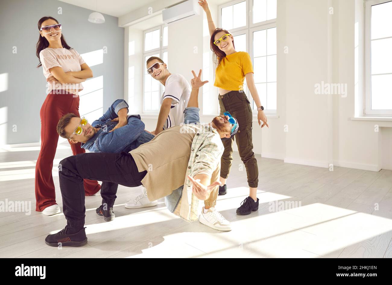 Team of cheerful young dancers have fun while performing hip-hop or break dancing in studio. Stock Photo