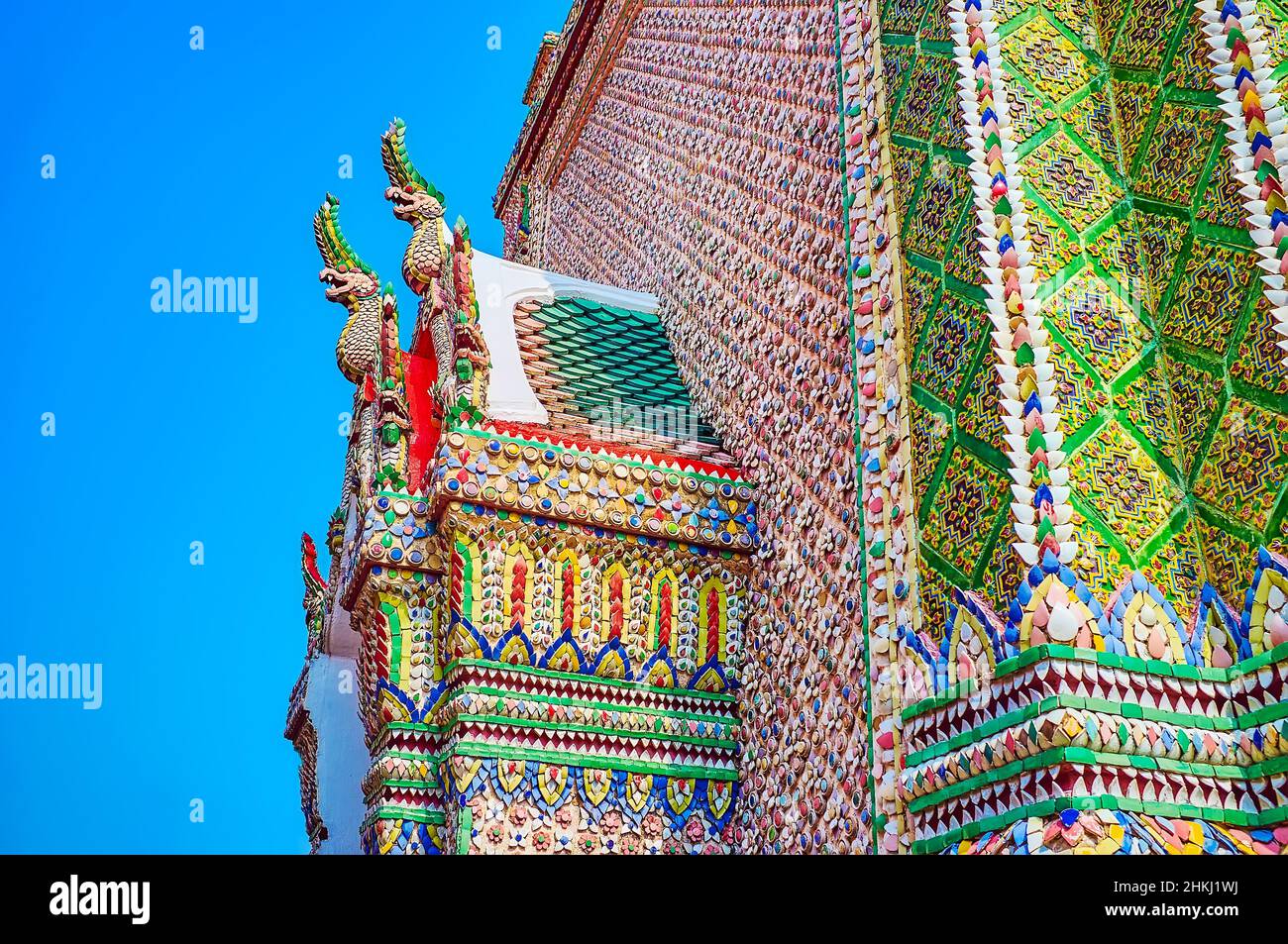 Ceramic tiles decoration of the facade of Ho Rakhang in typic Thai style with Nagas on ceilings, Grand Palace of Bangkok, Thailand Stock Photo