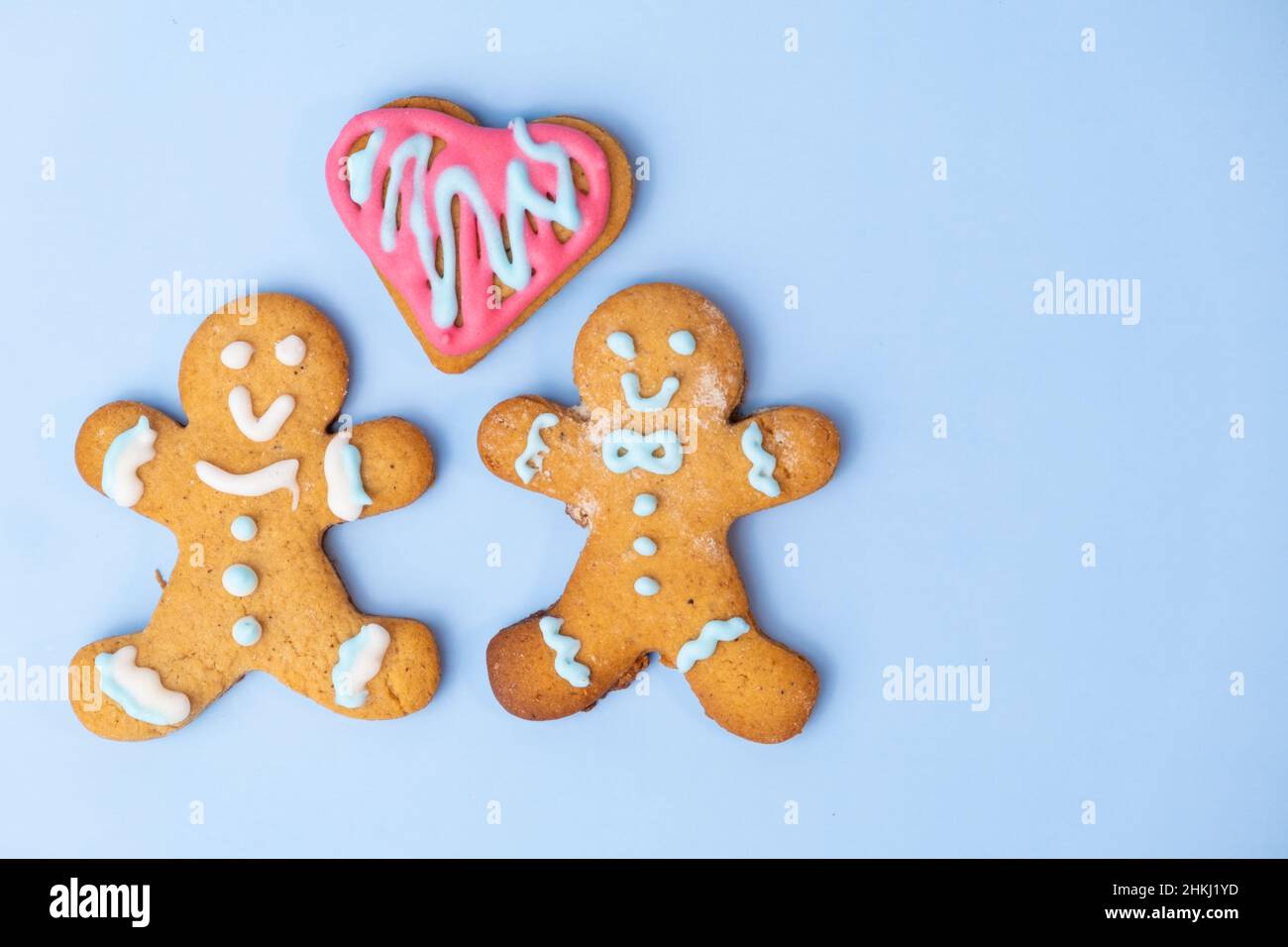 Black and white homosexual couple, two gingerbread girls and heart on the blue background with copy space for St Valentines Day.  Stock Photo