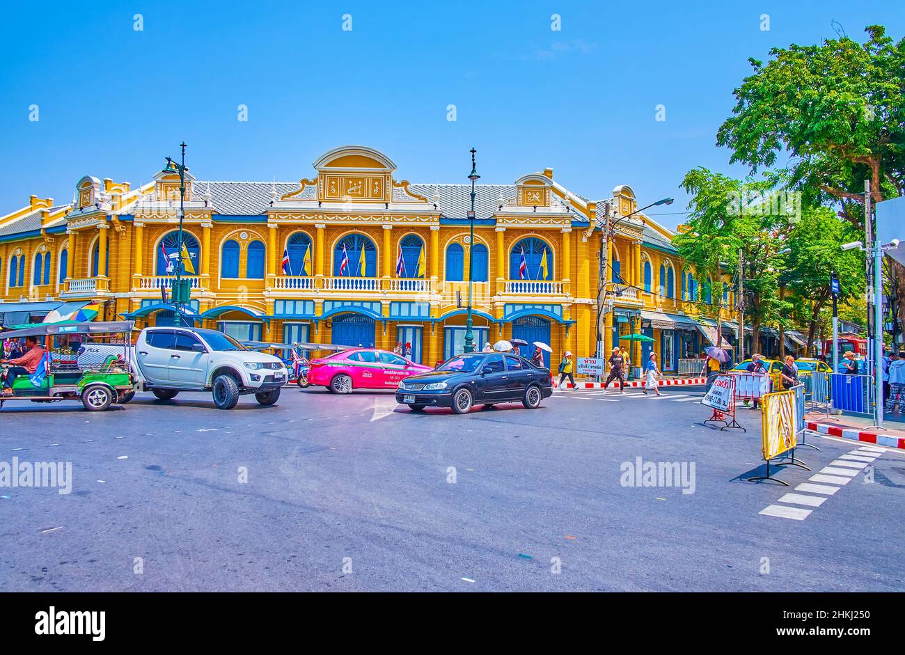 BANGKOK, THAILAND - MAY 12, 2019: The buzy crossroad and yellow building of Thapha library, Silpakorn University, on May 12 in Bangkok, Thailand Stock Photo