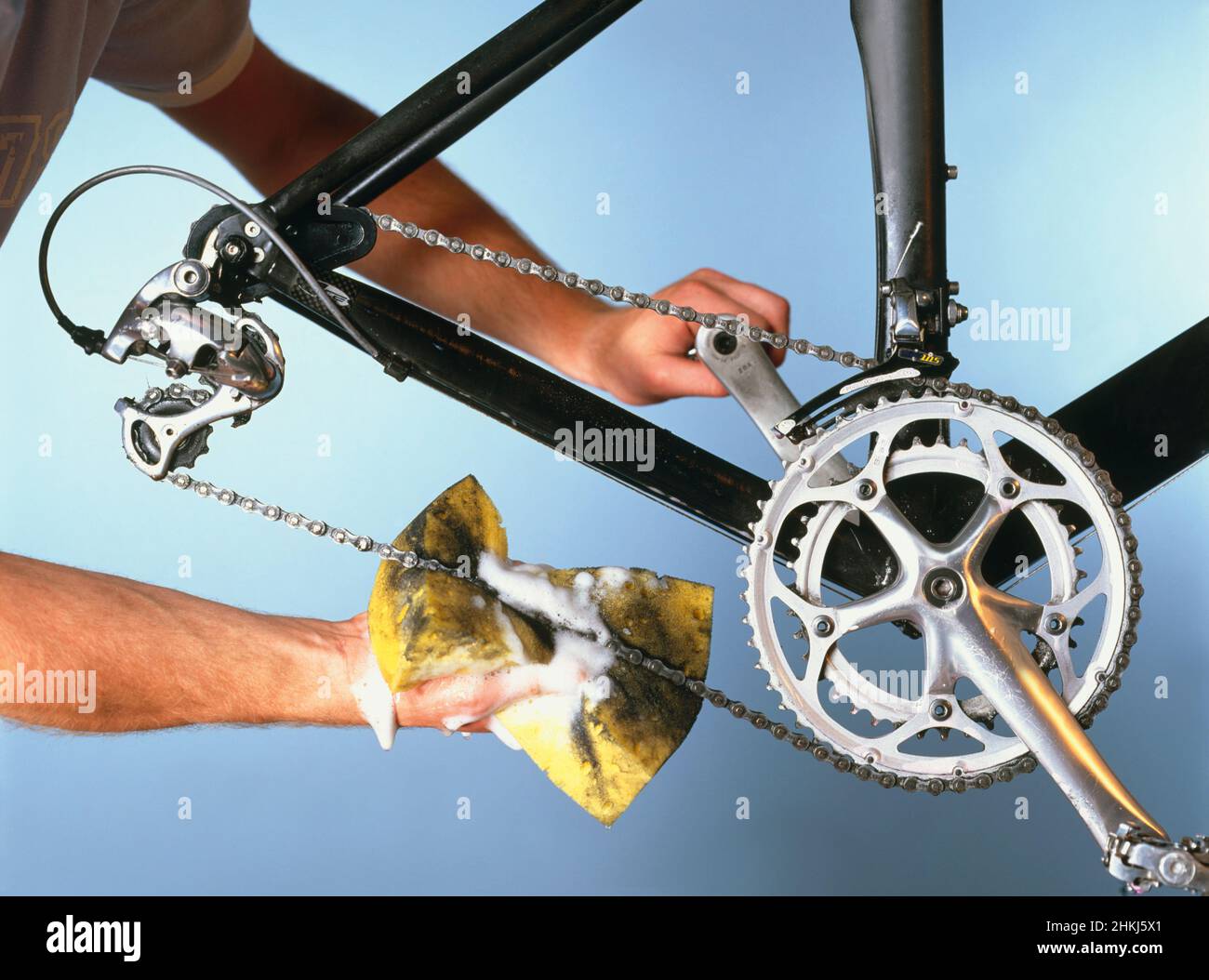 Man using sponge and soapy water to clean bicycle chain Stock Photo Alamy