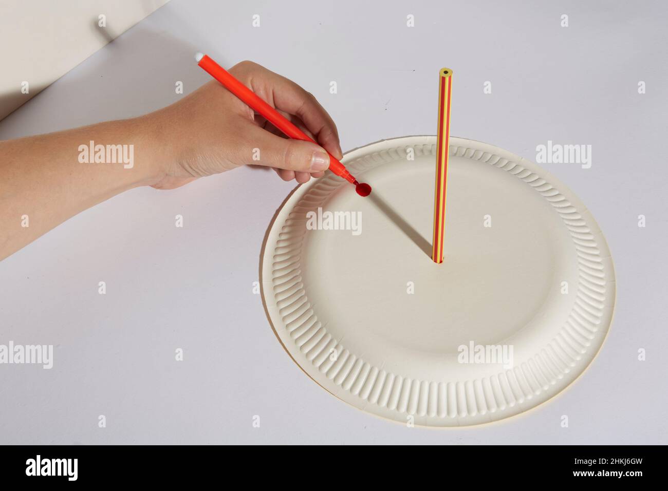 Creating a homemade sundial with a pencil and a paper plate Stock Photo