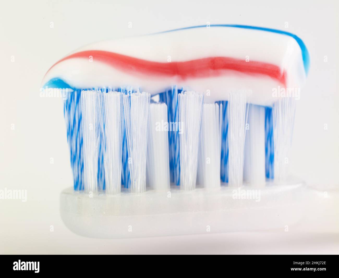 Striped toothpaste on a toothbrush head Stock Photo
