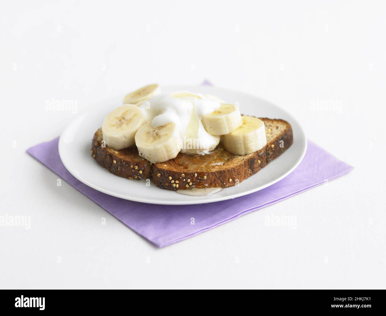 Banana, yoghurt and honey on wholemeal toast Stock Photo Alamy