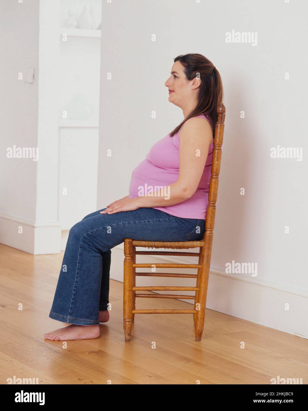 Pregnant woman sitting upright in chair Stock Photo Alamy