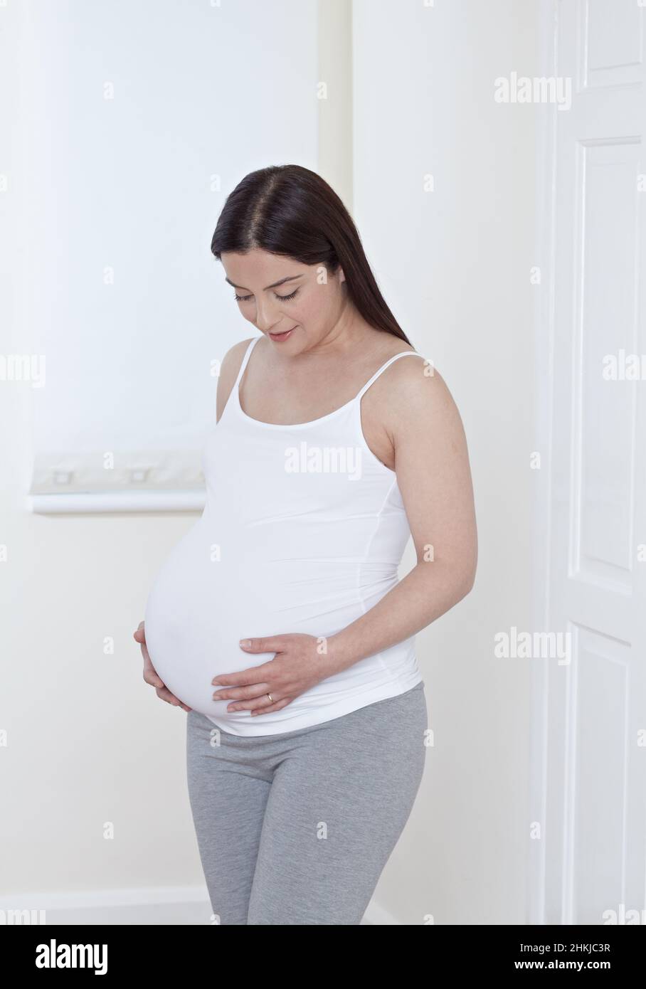 Mother holding her pregnant belly Stock Photo - Alamy