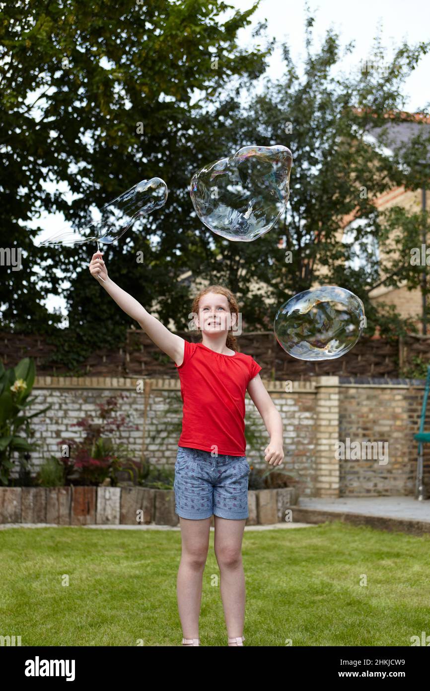 Making bubbles using wire clothes hanger as bubble wand Stock Photo Alamy