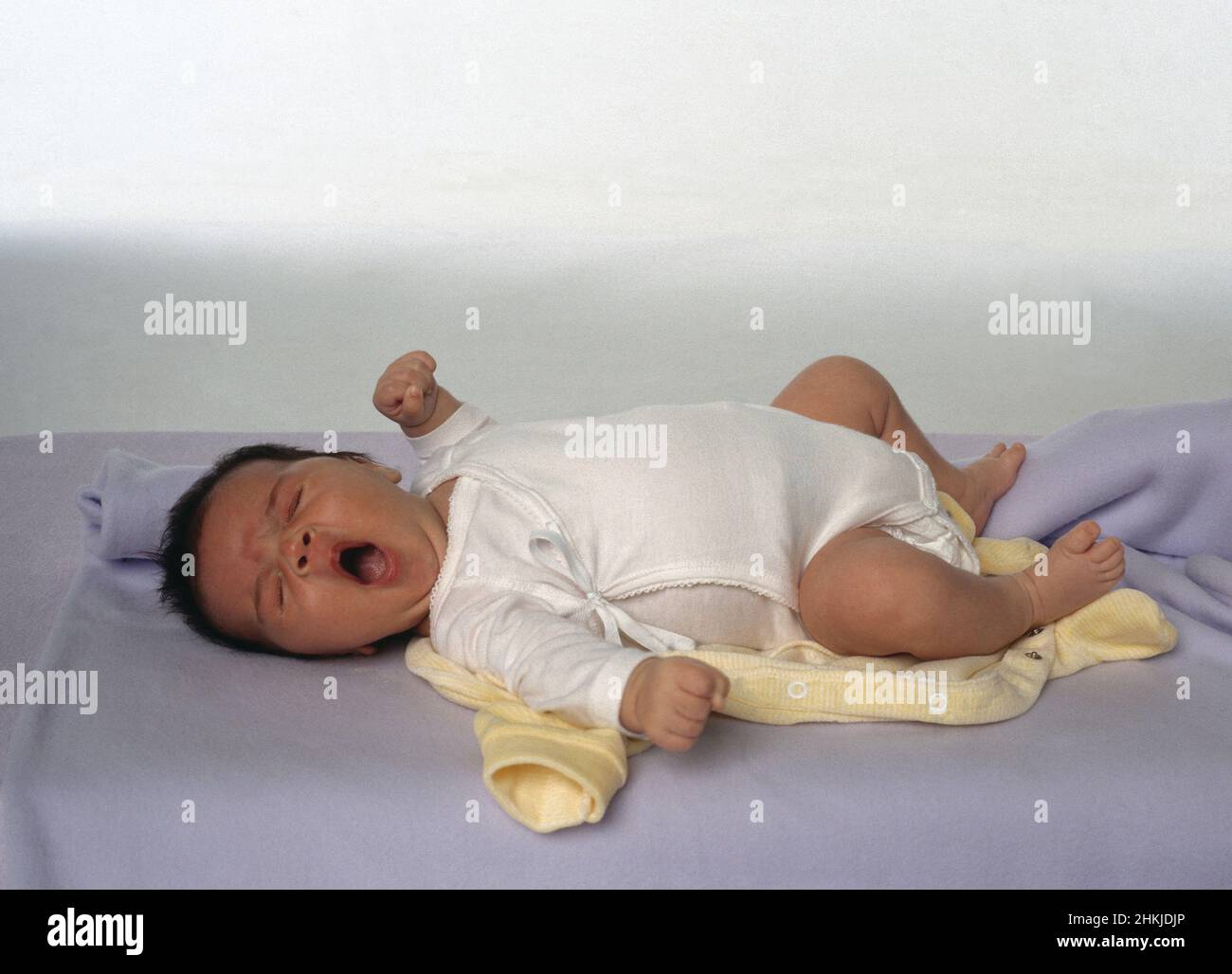 Baby lying down and yawning Stock Photo Alamy