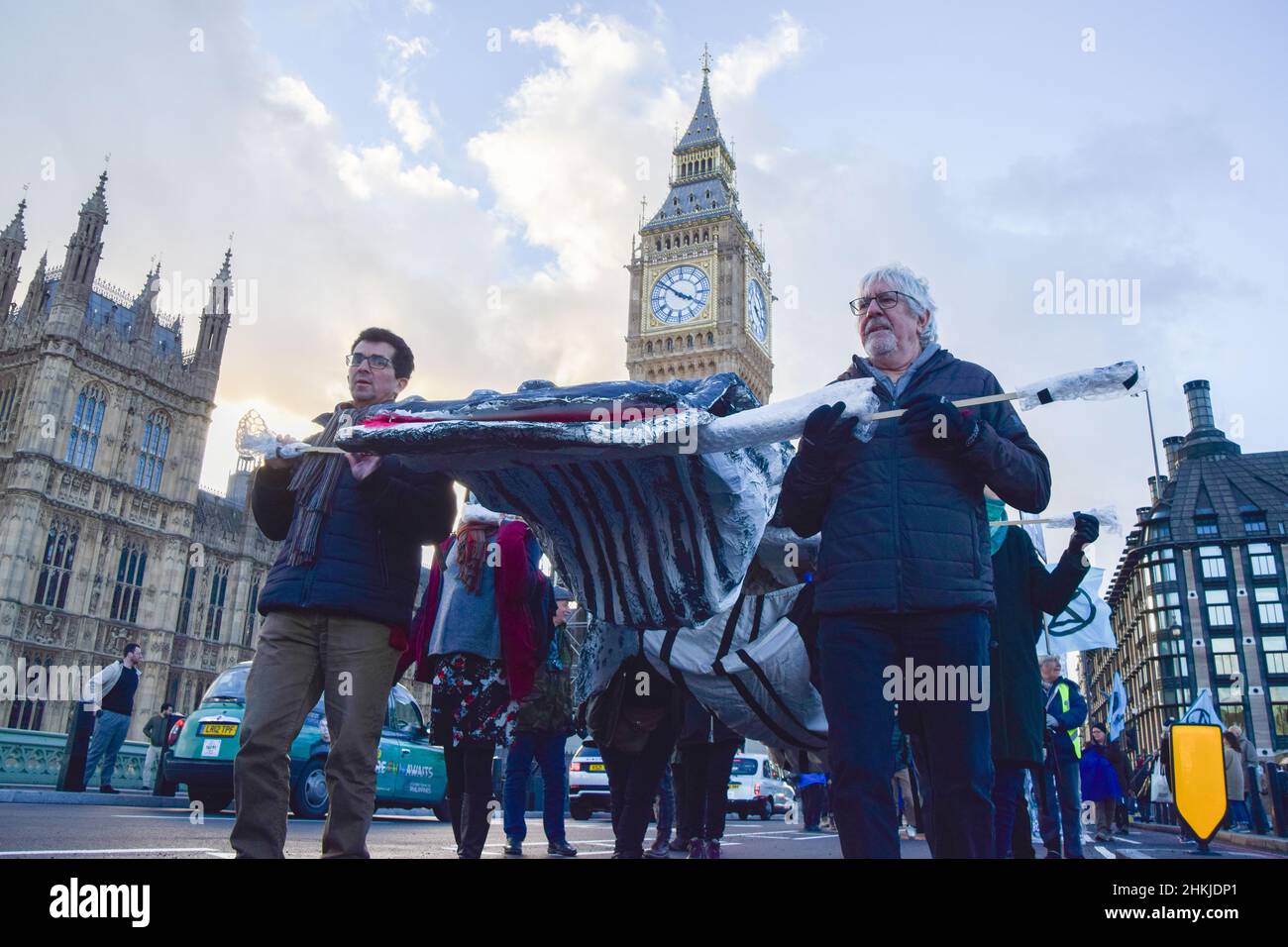 London, UK. 04th Feb, 2022. Demonstrators carry a model whale on Westminster Bridge during the protest. Activists marched with a model whale from Parliament Square to Shell's London headquarters as part of the Global Coastline Rebellion, in protest against the destruction of oceans and ocean wildlife caused by fracking, drilling, seismic surveys and pollution by oil companies. (Photo by Vuk Valcic/SOPA Images/Sipa USA) Credit: Sipa USA/Alamy Live News Stock Photo