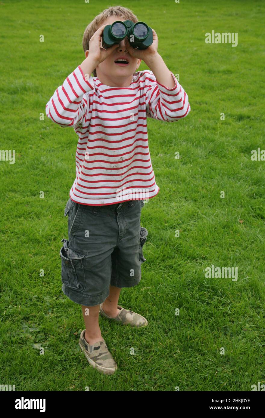 Boy looking through binoculars Stock Photo