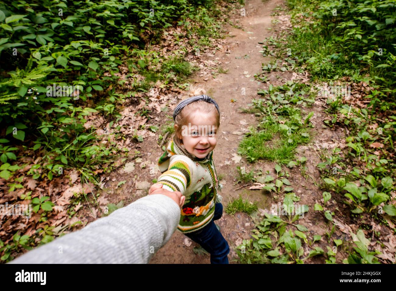 Girl pulling mom in the woods on a hike Stock Photo
