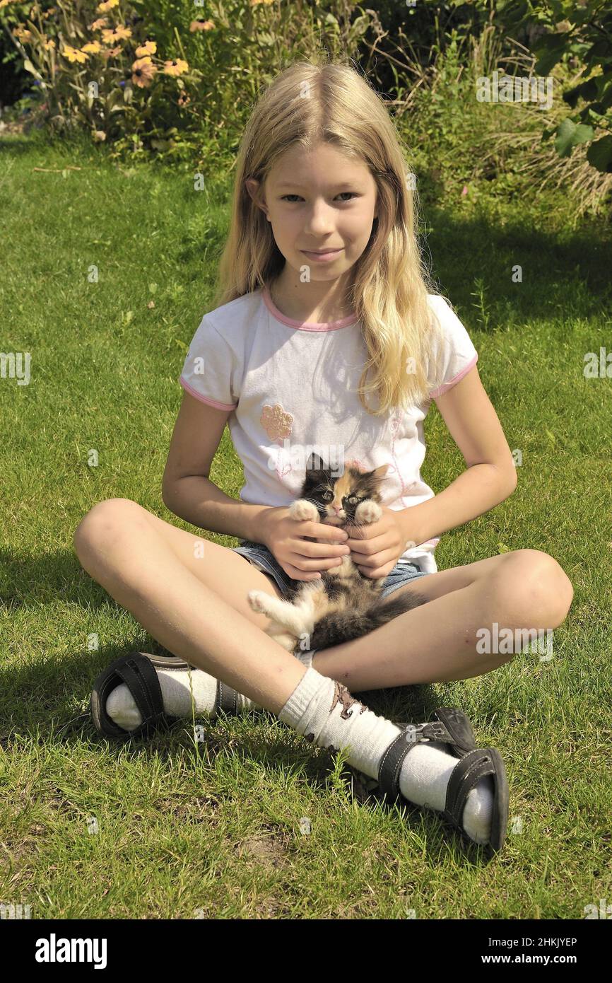 domestic cat, house cat (Felis silvestris f. catus), blond girl sitting