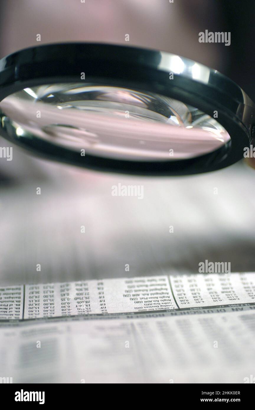 magnifying glass over stock prices of a newspaper Stock Photo