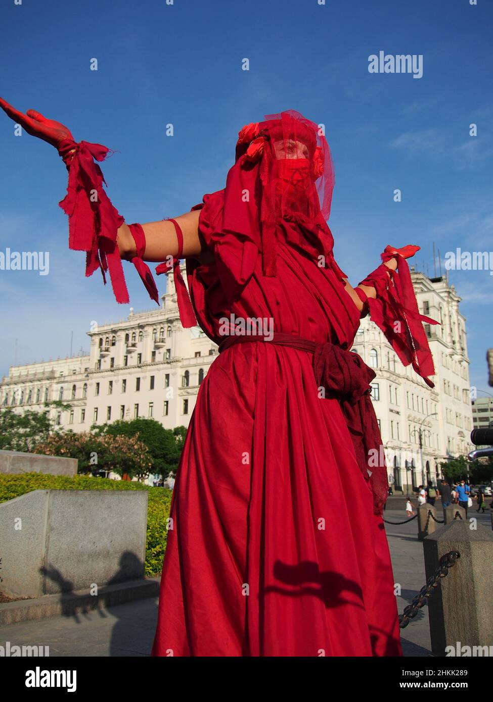 Peru. 04th Feb, 2022. An activist woman from Extinction Rebellion, dressed  in red, performs in a public square when dozens of demonstrators gather one  more time in the streets to protest for