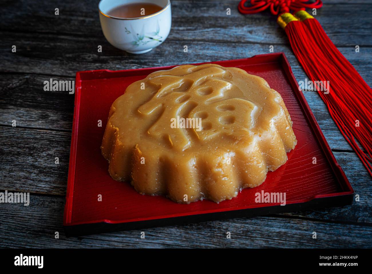 Traditional Chinese New Year sweet rice cake dessert known as Nian Gao, which is made from steamed glutinous rice flour batter. Rice cake with Chinese Stock Photo
