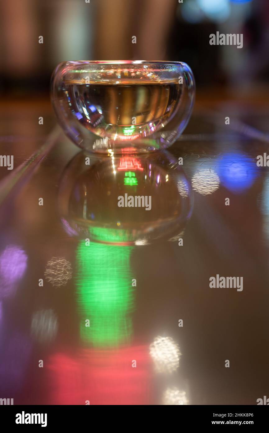 Glassware for hot beverages over blurred background, colorful neon light. Clean teacup.  Stock Photo
