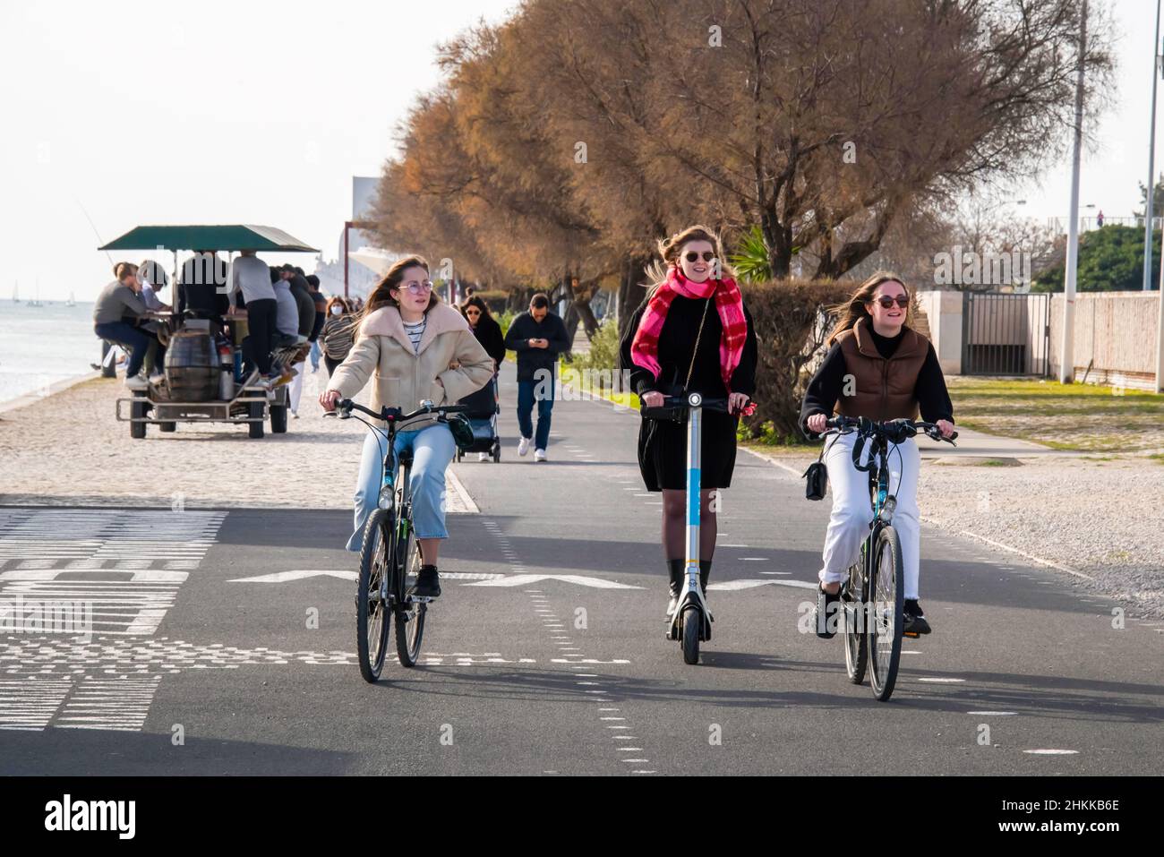 Women ride bikes and a scooter on the boulevard near the 25 de Abril Bridge. The Portuguese Council of Ministers has approved a Law Decree that puts an end to the requirement