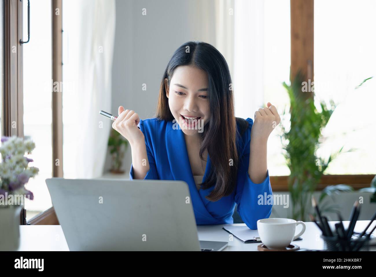 Asian Woman blogger wear blue suit talking with followers, live streaming on social media application. Freelance work from home concept. Stock Photo