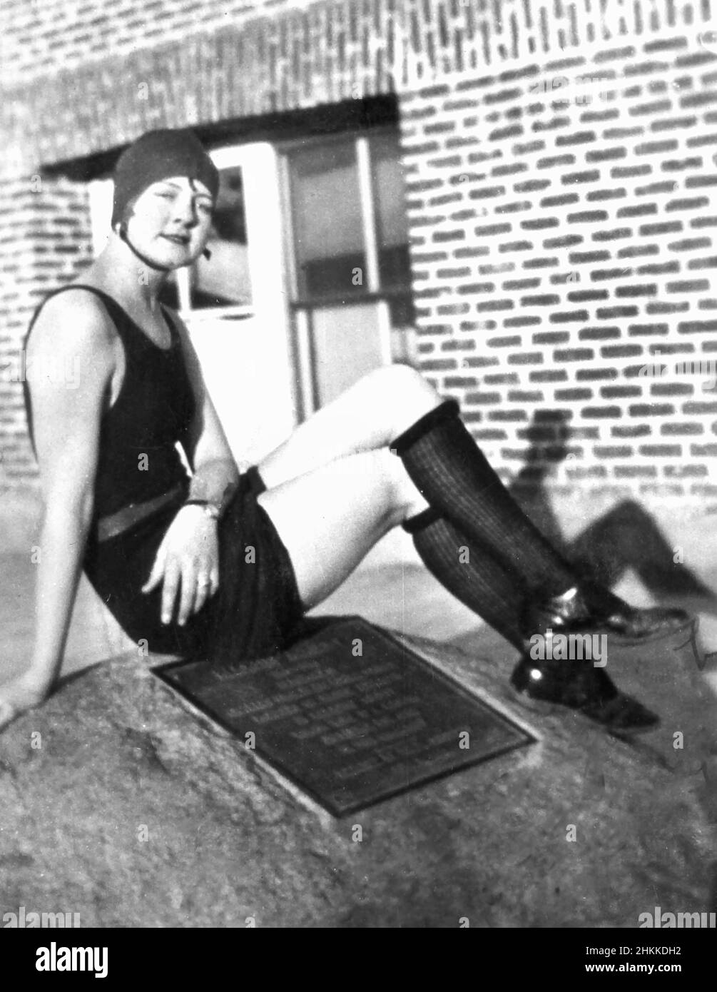 A sexy flapper woman sits atop a landmark rock, ca. 1925. Stock Photo