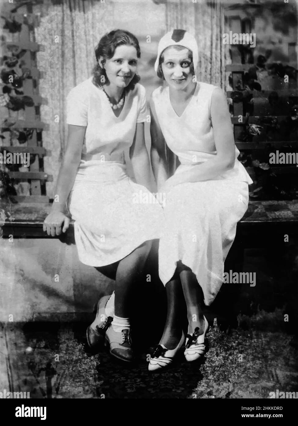 Two young women sit together and pose, ca. 1930. Stock Photo