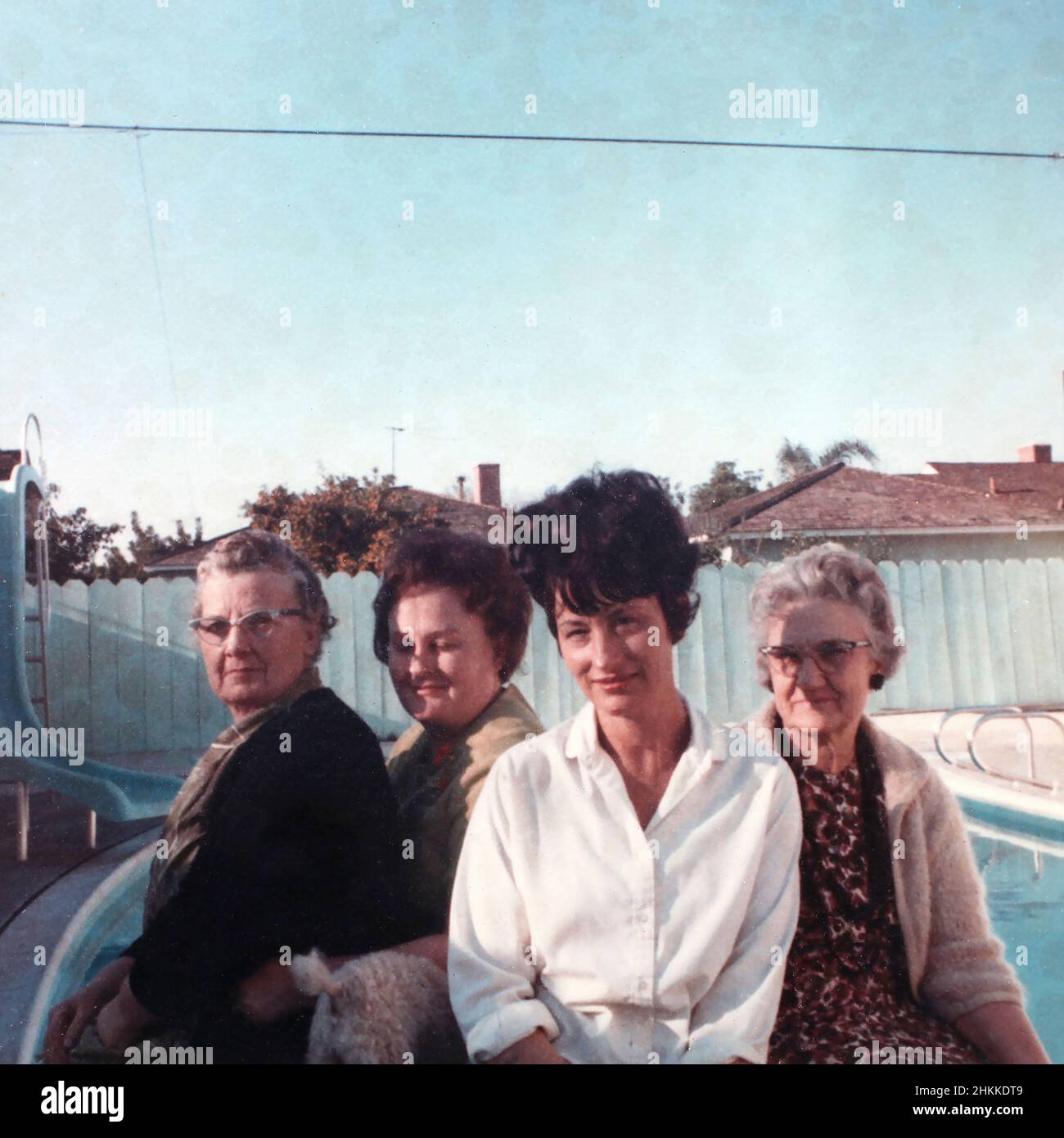 Four women pose next to the pool in a suburban U.S. backyard, ca. 1968. Stock Photo