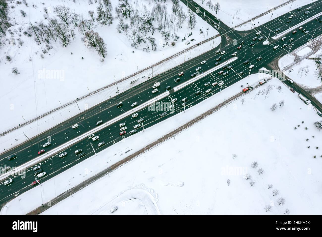 highway intersection in snow-covered suburb area with cars traffic. aerial view. Stock Photo