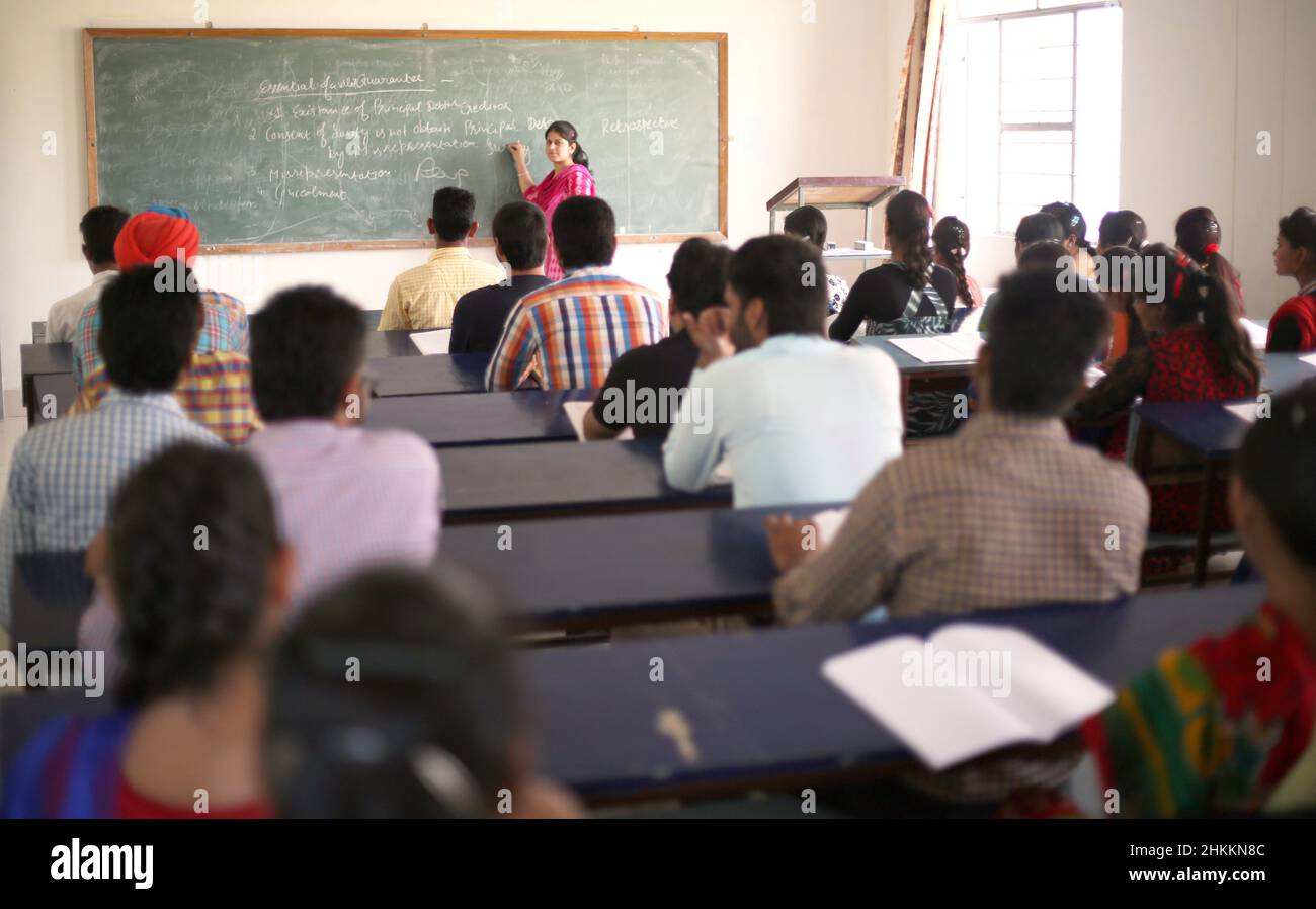 Young students in university College Classroom in India attending lecture with lecturer Stock Photo