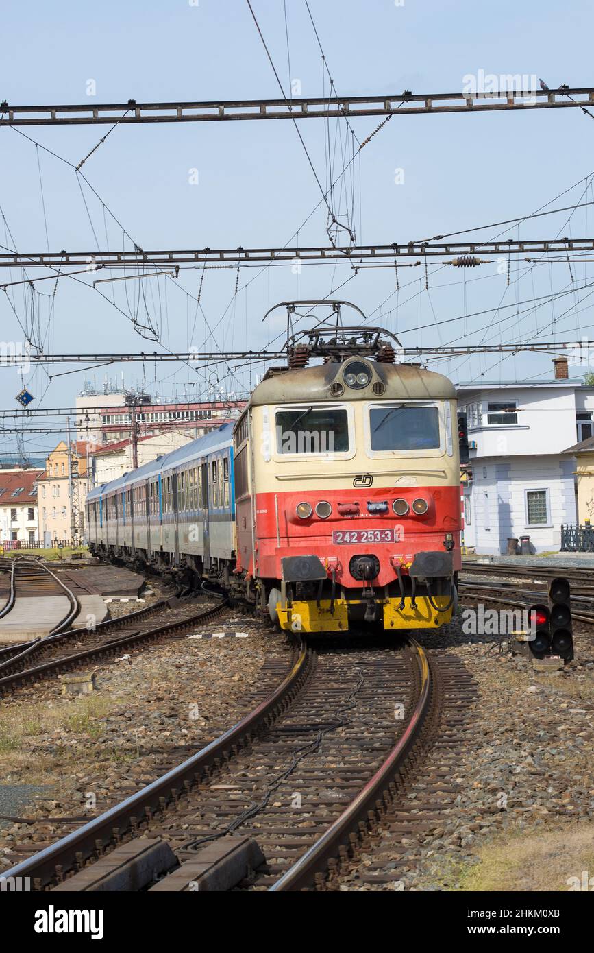 BRNO, CZECH REPUBLIC - APRIL 24, 2018: Electric locomotive Skoda 242.253-3 with a commuter train arrives to station on a sunny day Stock Photo