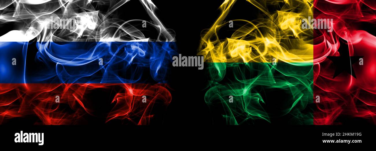 Russia, Russian vs Guinea Bissau flags. Smoke flag placed side by side isolated on black background. Stock Photo