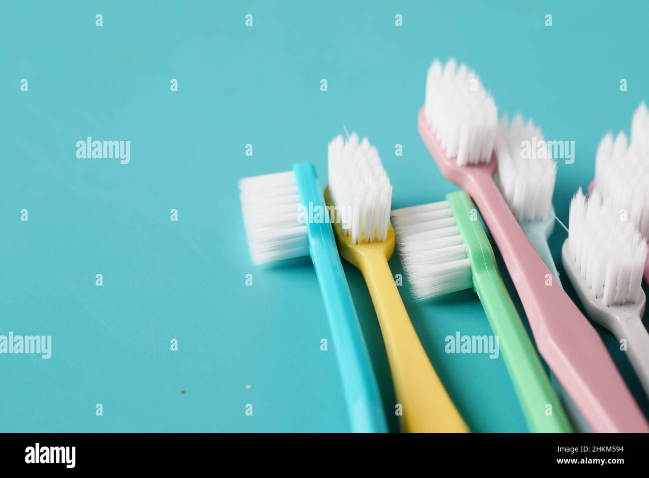 colorful toothbrushes on light green background Stock Photo - Alamy