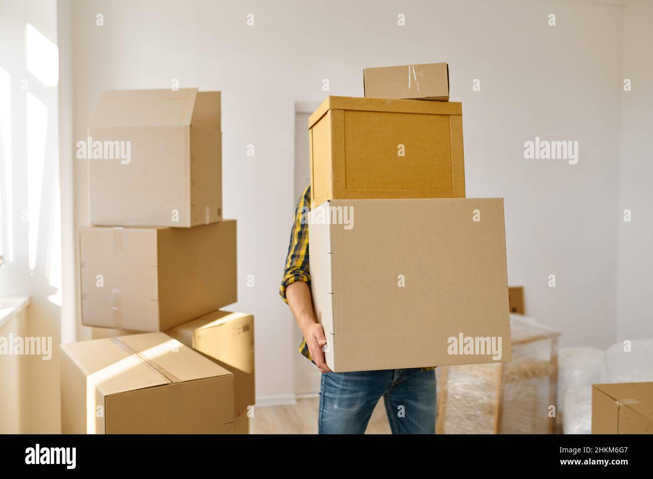 Man carrying many cardboard boxes in stack Stock Photo