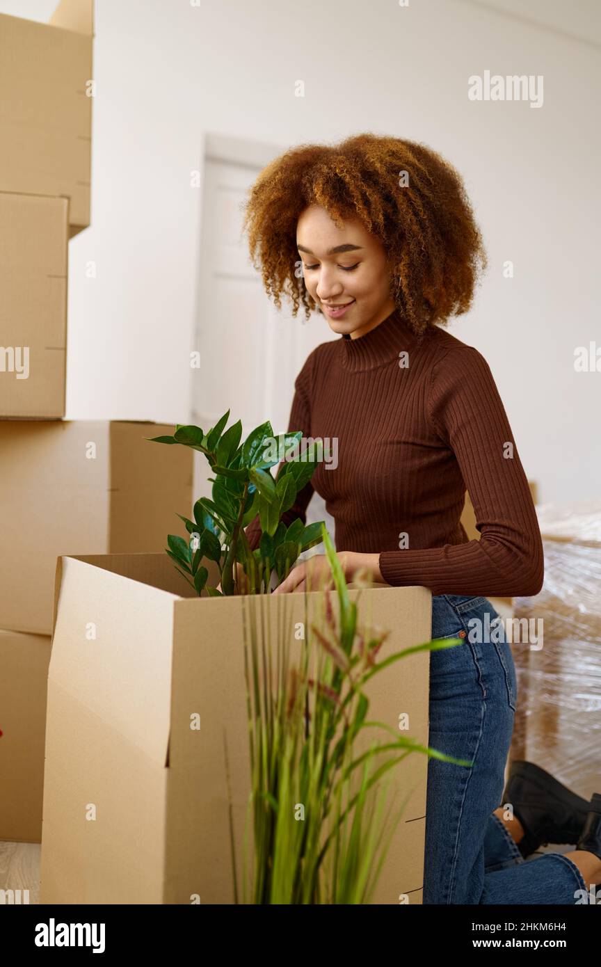 Young woman packing flower during moving day Stock Photo