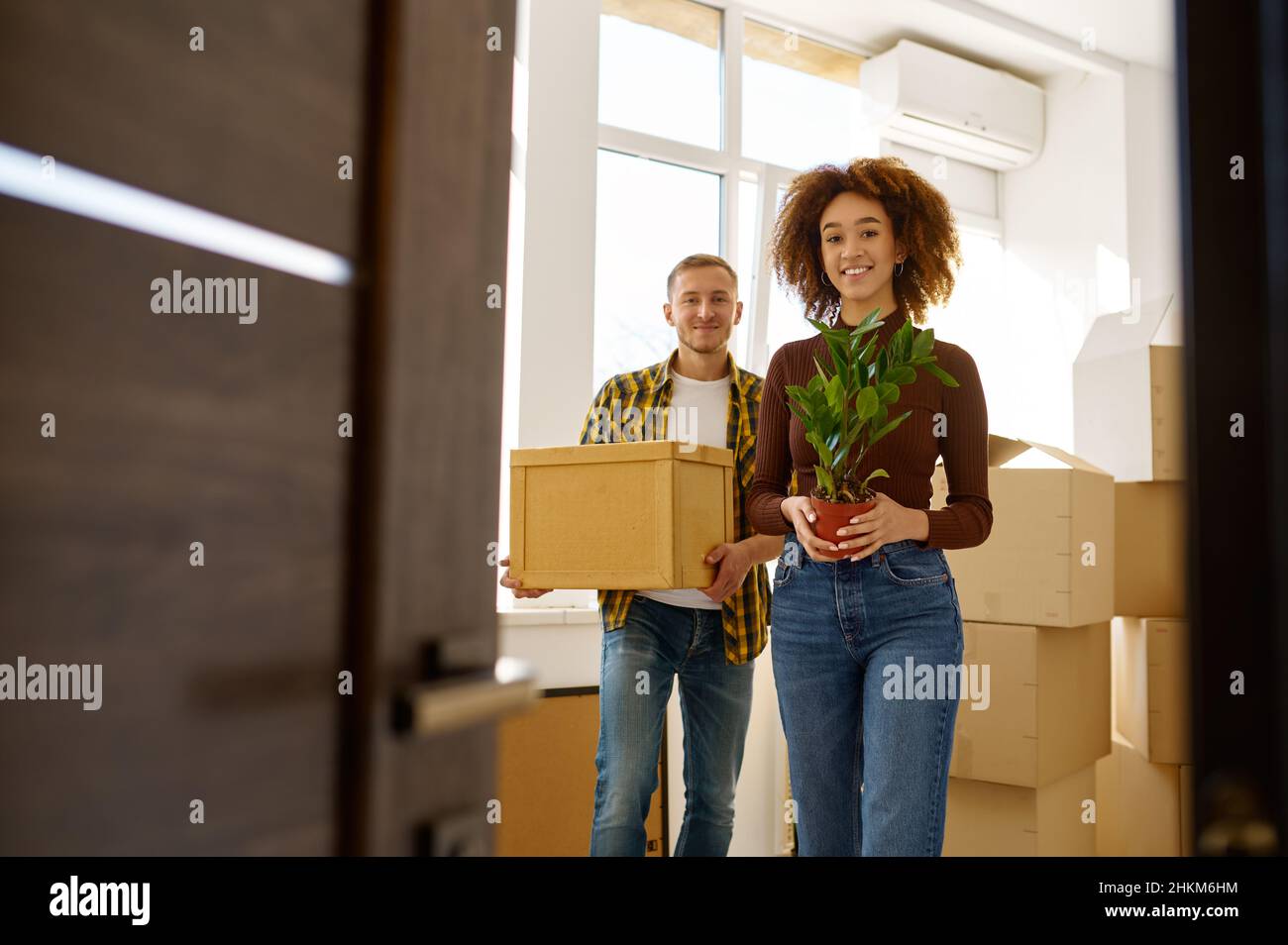 Couple on moving day carrying cardboard boxes Stock Photo