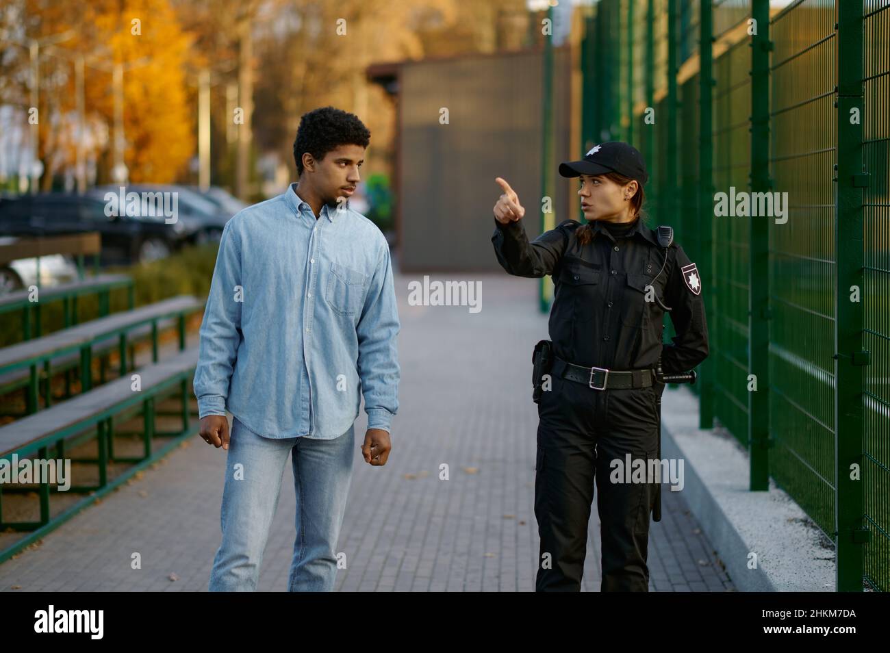 Police woman showing way to man passerby Stock Photo