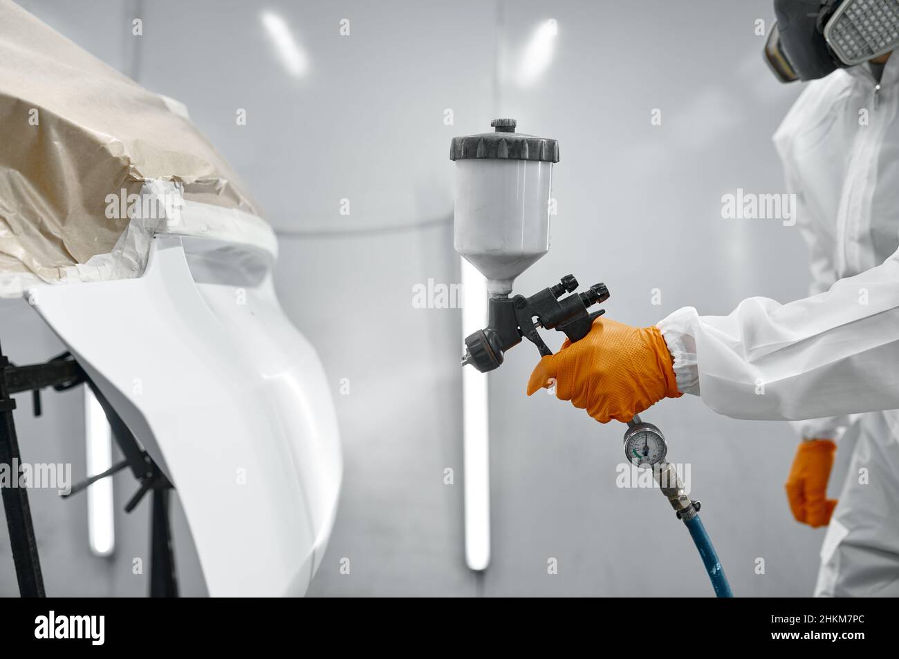 Technician in safety clothing spraying car paint Stock Photo