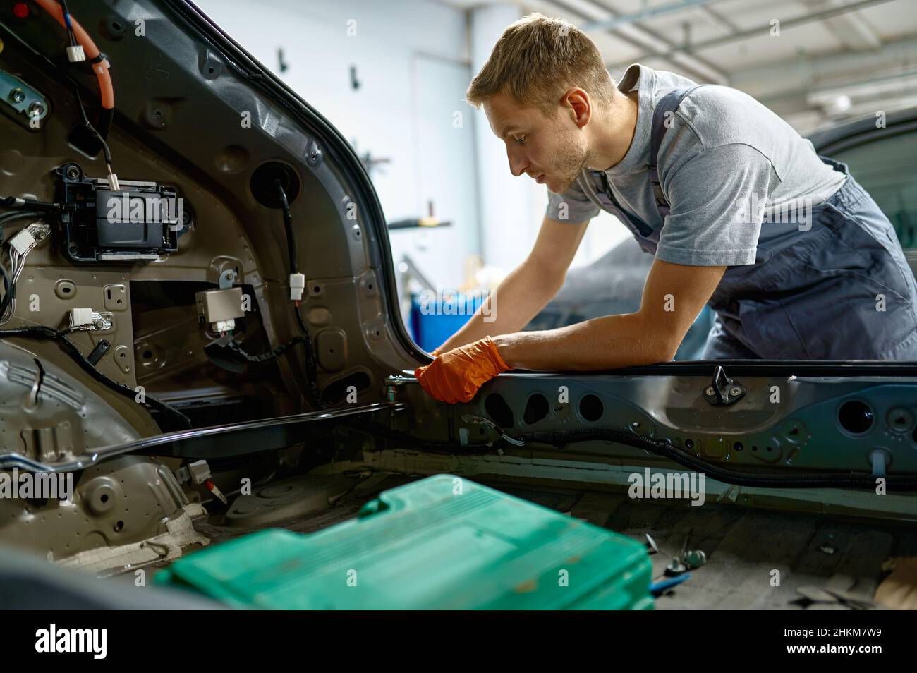 Workman fixing bolt during car body repair Stock Photo - Alamy