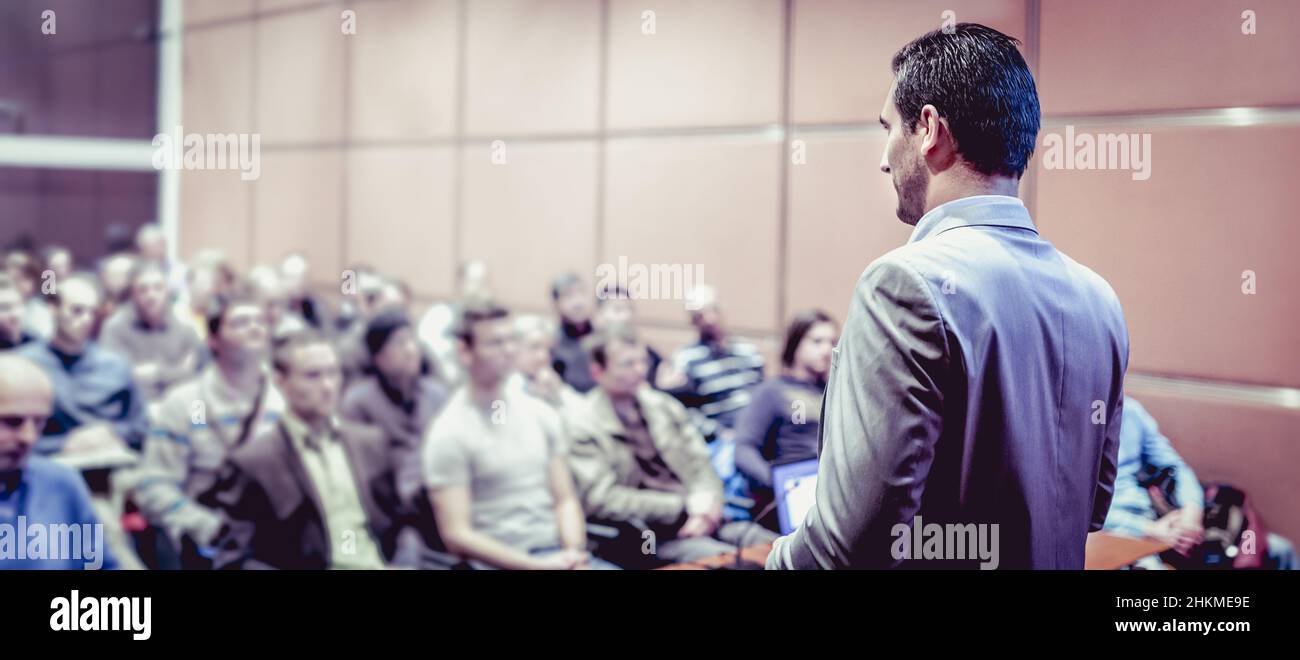 Speaker giving a talk on corporate business conference. Unrecognizable people in audience at conference hall. Business and Entrepreneurship event Stock Photo