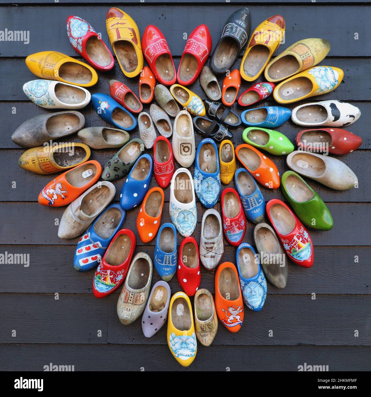 multicolored vintage dutch wooden shoes in shape of heart on black wood  panel background Stock Photo - Alamy