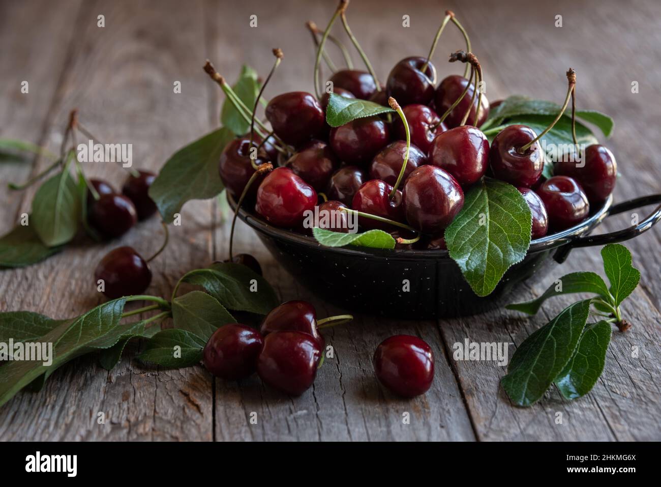 Fresh ripe dark cherries with green leaves Stock Photo - Alamy