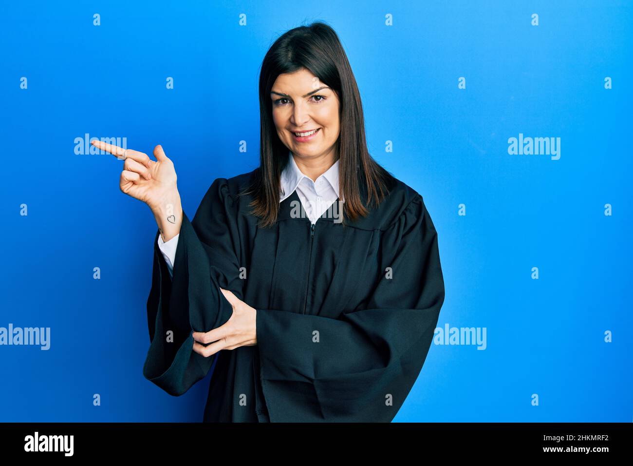 Young hispanic woman wearing judge uniform with a big smile on face