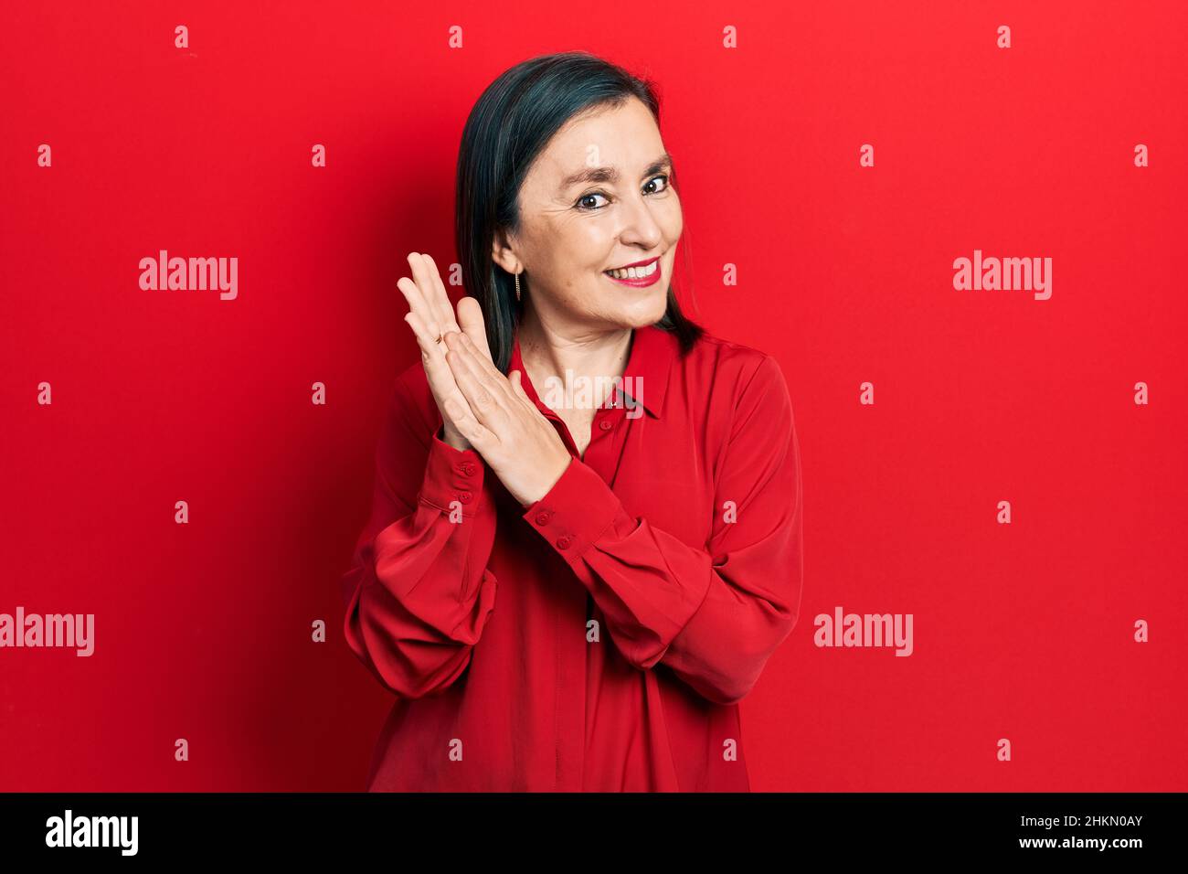 Middle age hispanic woman wearing casual clothes clapping and ...