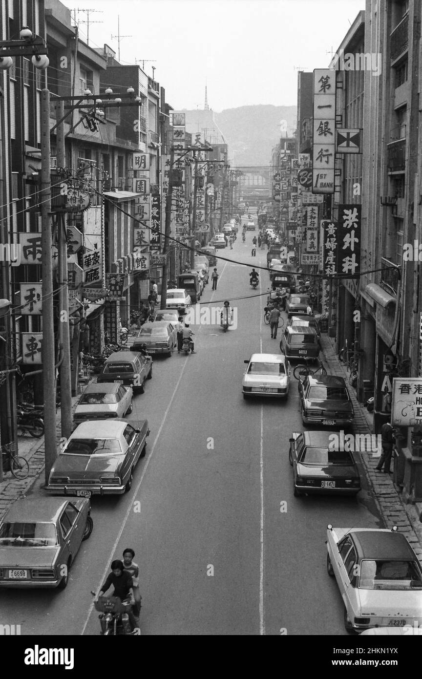 Street scene with cars, bikes, motorbikes and shops, with  signs in Chinese, Keelung, Taiwan, April 1978 Stock Photo
