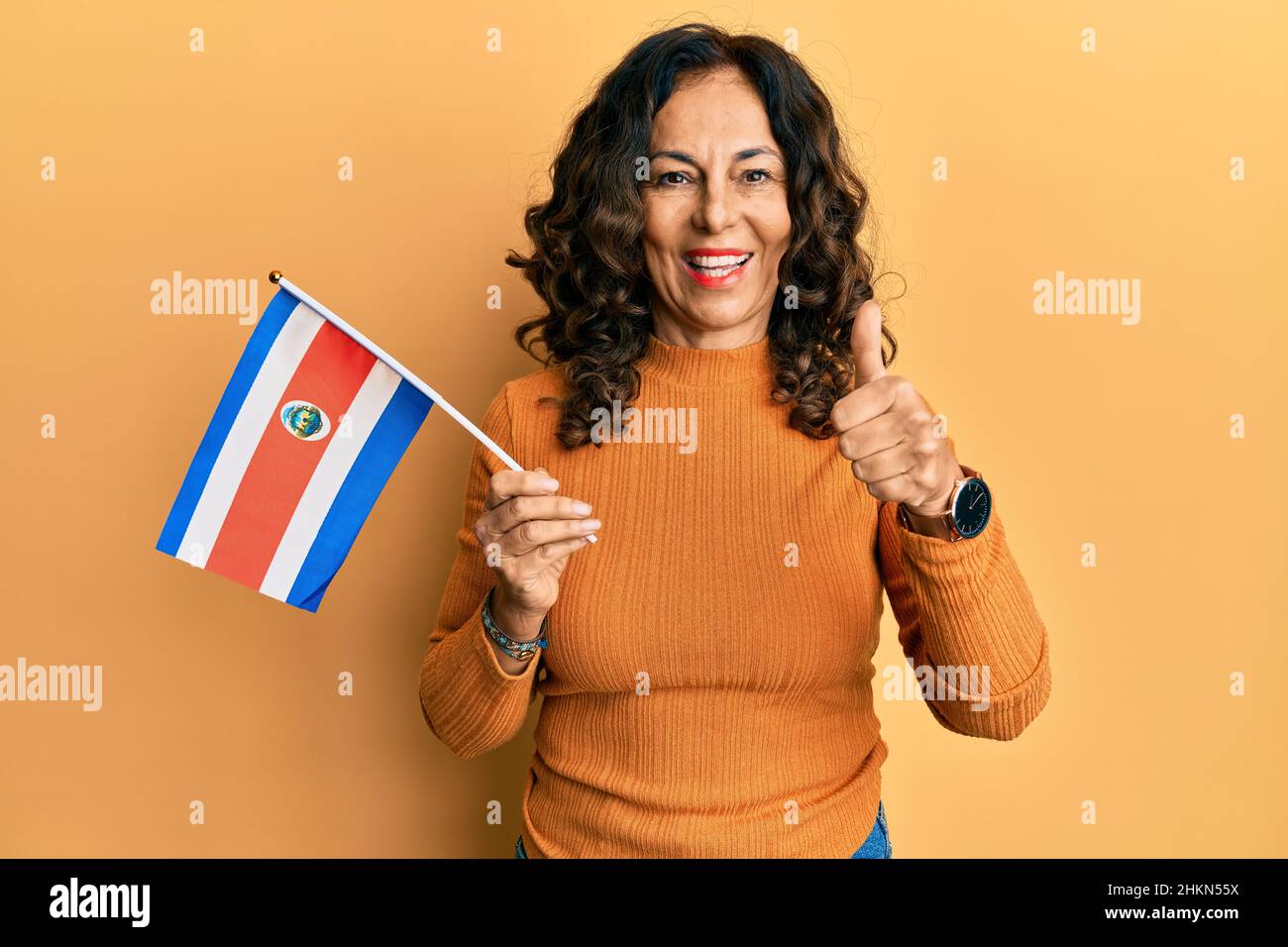 Middle age hispanic woman holding costa rica flag smiling happy and ...